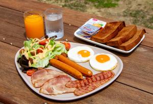 a plate of food with eggs bacon toast and eggsurrection at Maison Du Lac The Safari Tent in Wang Nam Khieo