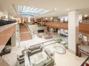 eine große Lobby mit Sofas und einer Treppe in der Unterkunft Awashima Hotel in Numazu