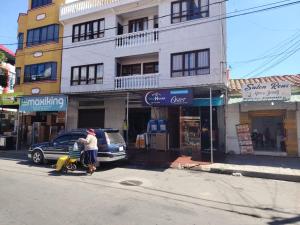 a man standing next to a car on a city street at The House Tarija in Tarija