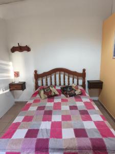 a bedroom with a bed with a checkered blanket at Cabañas Tierra del molino in General Alvear +4 photos