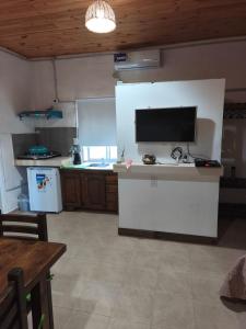 a kitchen with a white counter with a tv on it at Cabañas Tierra del molino in General Alvear