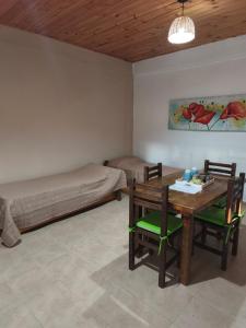 a room with a table and a bed and a table and chairs at Cabañas Tierra del molino in General Alvear