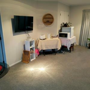 a living room with a table and a tv at One8Endeavour in Tauranga