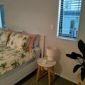 a living room with a couch and a table with a lamp at One8Endeavour in Tauranga