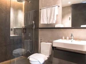 a bathroom with a toilet and a sink and a shower at Maisola by ARTOTEL Semarang in Semarang +42 photos