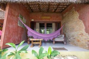 a hammock on the porch of a house at Hotel Ponta do Madeiro in Pipa