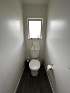 a small bathroom with a toilet and a window at Town Centre Retreat in Taupo +3 photos