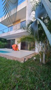 a building with a palm tree in front of it at Bustani Villa in Nyamanzi Kazole