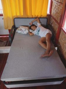 a young girl laying on a bed at Check beth in Puerto Princesa City