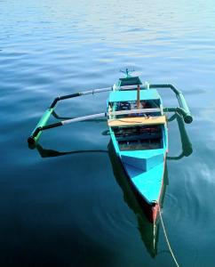 a small blue boat in the water at Check beth in Puerto Princesa City