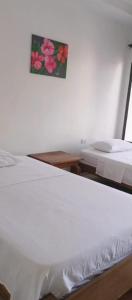 a bed in a room with a picture on the wall at GTH Hostal in Arboletes