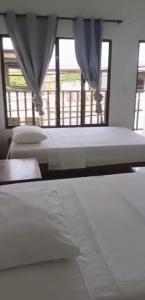 a bedroom with two beds and a window at GTH Hostal in Arboletes
