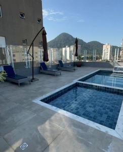 a swimming pool on the roof of a building at Lindo Apê Canto do Forte com lazer completo in Praia Grande