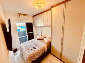 a small bedroom with a bed and a window at Lindo Apê Canto do Forte com lazer completo in Praia Grande +12 photos
