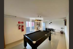 a room with a pool table and a dining room at Lindo Apê Canto do Forte com lazer completo in Praia Grande