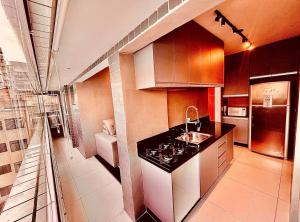 a kitchen with a sink and a counter top at Lindo Apê Canto do Forte com lazer completo in Praia Grande