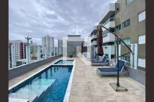 a swimming pool on the roof of a building at Lindo Apê Canto do Forte com lazer completo in Praia Grande