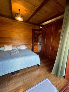 a bedroom with a bed in a wooden room at Manuia House in Bora Bora
