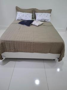 a bed in a room with a white floor at Recanto do Sol em Marica in Maricá