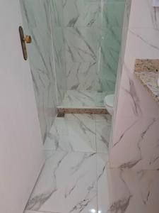 a bathroom with a marble shower with a toilet at Recanto do Sol em Marica in Maricá +37 photos