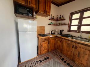a kitchen with a white refrigerator and wooden cabinets at Manuia House in Bora Bora