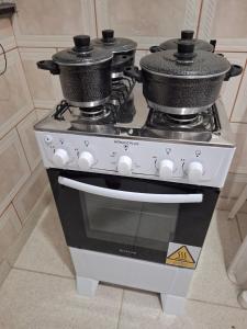 a stove with two pots on top of it at Recanto do Sol em Marica in Maricá