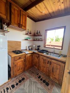a kitchen with wooden cabinets and a sink and a window at Manuia House in Bora Bora