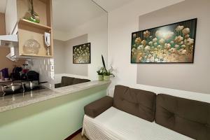 a living room with a couch and a painting on the wall at Asa Sul | Próx. Aeroporto | Conforto & Praticidade in Brasília