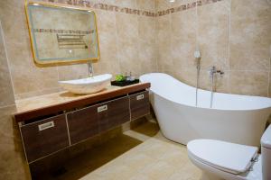 a bathroom with a tub and a toilet and a sink at An Gia Hotel in Quy Nhon