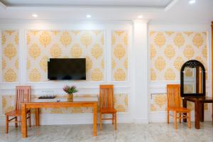 a dining room with a table and chairs and a tv at An Gia Hotel in Quy Nhon