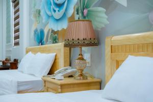a bed room with a lamp and a phone on a table at An Gia Hotel in Quy Nhon