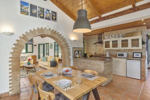 a kitchen and a dining room with a table and chairs at Casa Brisa Do Rio, Malhada do São - Rural in Tavira