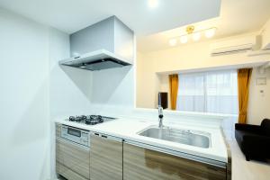 a kitchen with a sink and a stove at CREST Nishijin by Tranova in Fukuoka