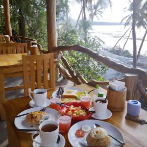a table with plates of food and coffee on it at BaraCoco Bungalows in Bira +32 photos