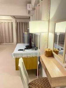a room with a table with a lamp and a mirror at A Day Rayong in Ban Pa Khan
