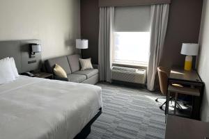 a hotel room with a bed and a couch at Comfort Inn & Suites in Lubbock +5 photos