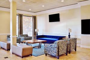 a living room with a blue couch and chairs at Radisson Hotel Orlando Lake Buena Vista South in Kissimmee
