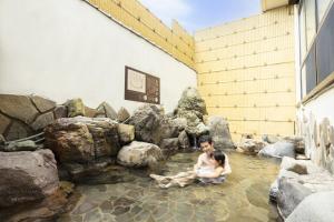 two people sitting in the water at a zoo at Ooedo Onsen Monogatari Yamashiro Saichoraku in Kaga