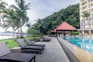 a row of lounge chairs next to a swimming pool at Laprima Hotel in Labuan Bajo