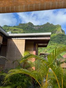 a house with a mountain in the background at Manuia House in Bora Bora