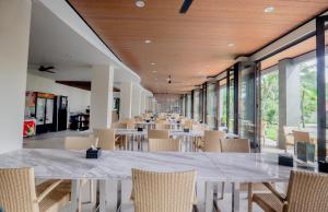 a long dining room with tables and chairs at Laprima Hotel in Labuan Bajo