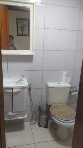 a bathroom with a toilet and a sink and a mirror at Kitinete holl in Campos dos Goytacazes