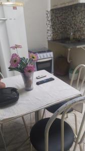a table with flowers on it in a kitchen at Kitinete holl in Campos dos Goytacazes