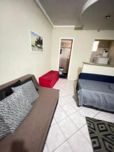 a bedroom with a bed and a red couch at Kitinete holl in Campos dos Goytacazes