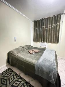 a bedroom with two beds and a window at Kitinete holl in Campos dos Goytacazes