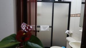 a bathroom with a door with a toilet and a sink at Departamento Macas in Macas
