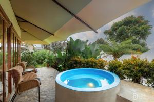ein Whirlpool auf einer Terrasse mit Sonnenschirm in der Unterkunft Alamu Eco Lodge in Bedugul