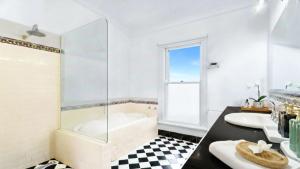 a bathroom with two sinks and a tub and a shower at Charming Heritage Retreat in Sale