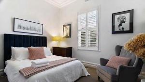 a bedroom with a large bed and a chair at Charming Heritage Retreat in Sale