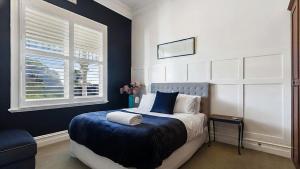 a bedroom with a bed with a blue blanket and a window at Charming Heritage Retreat in Sale +21 photos